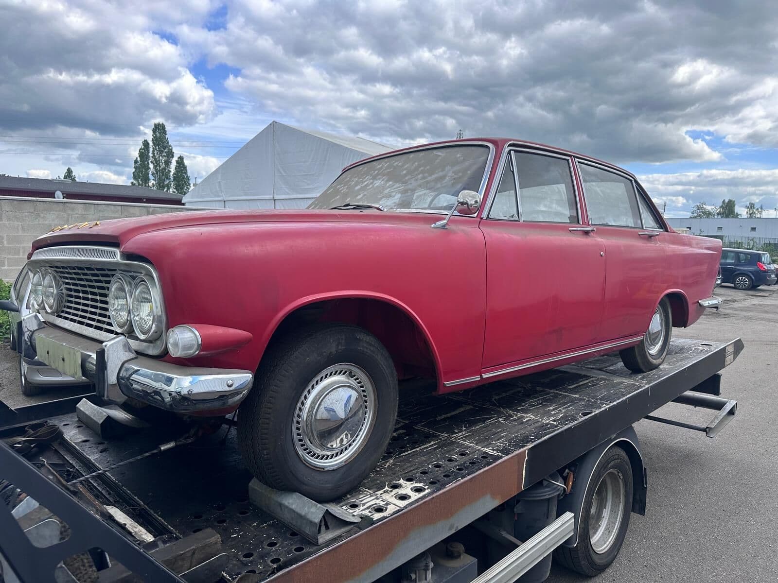 Voiture ancienne rouge transportée sur le plateau de la dépanneuse